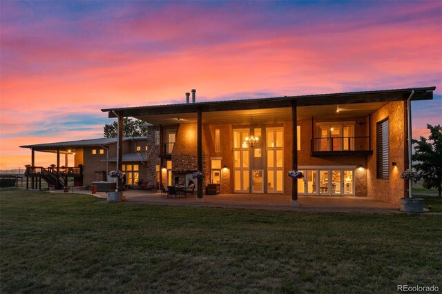 11881 County Road 37, Fort Lupton, CO 80621 - back of property at dusk featuring a yard, a patio area, and a balcony