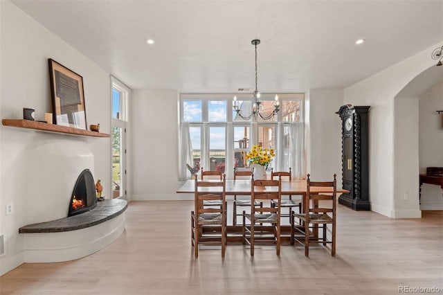 11881 County Road 37, Fort Lupton, CO 80621 - dining area with light wood finished floors, a chandelier, recessed lighting, and arched walkways