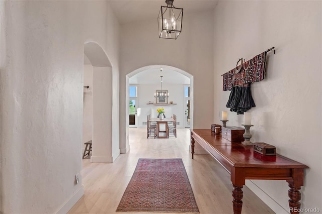 11881 County Road 37, Fort Lupton, CO 80621 - foyer entrance with a chandelier, arched walkways, light wood-style flooring, and a towering ceiling