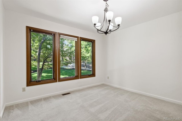 unfurnished room featuring an inviting chandelier and carpet flooring