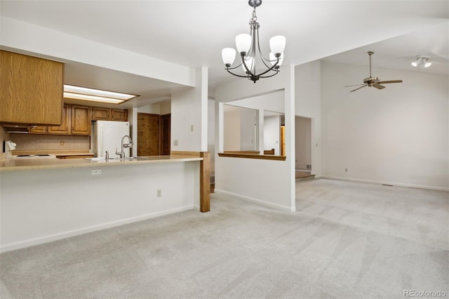 kitchen with light colored carpet, ceiling fan with notable chandelier, pendant lighting, and white fridge