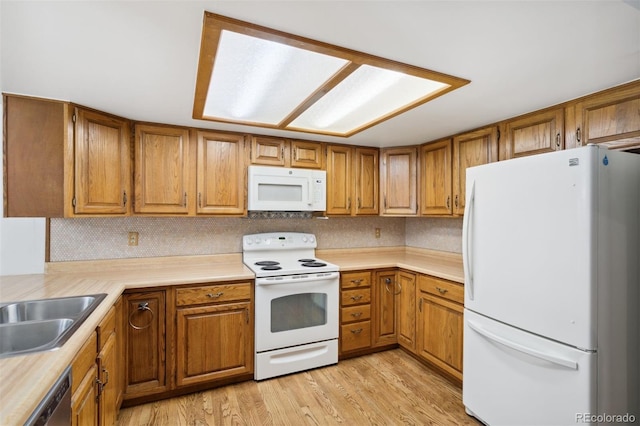 kitchen featuring sink, light hardwood / wood-style floors, and white appliances