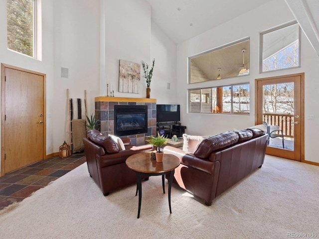 living room featuring carpet flooring, a fireplace, high vaulted ceiling, and baseboards