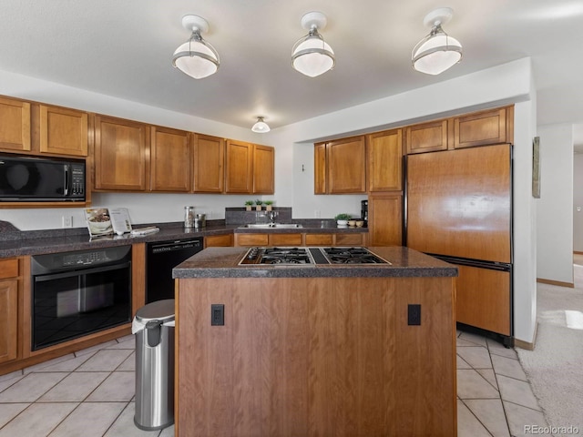 kitchen featuring a kitchen island, black appliances, light tile patterned flooring, and brown cabinetry