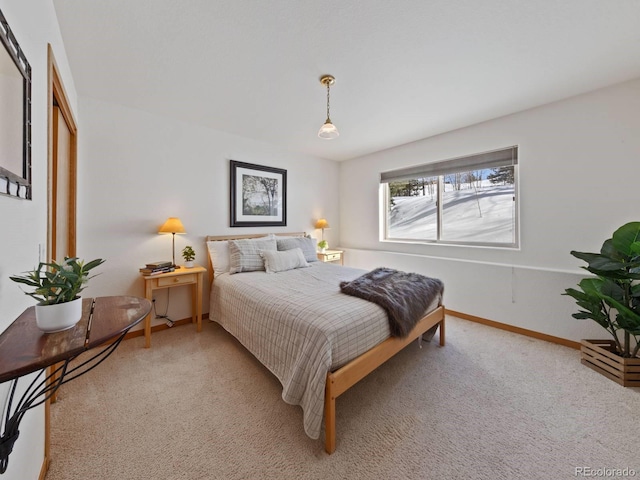 bedroom with light colored carpet and baseboards