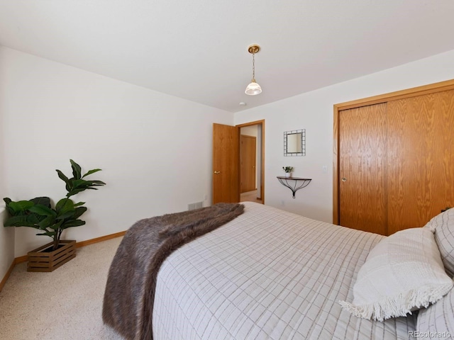 carpeted bedroom with baseboards, visible vents, and a closet