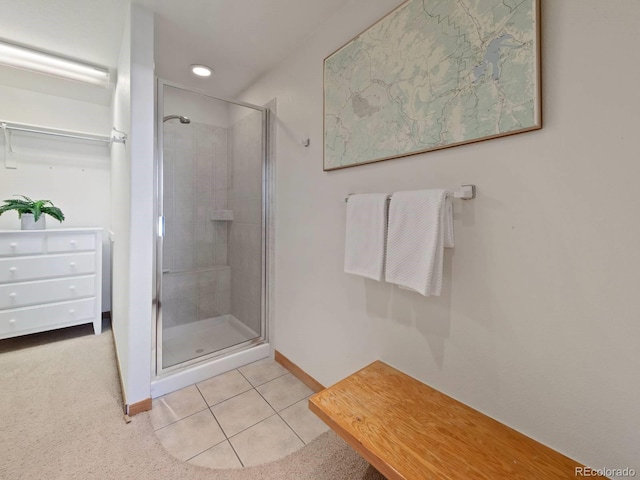 bathroom featuring baseboards, a shower stall, and tile patterned flooring