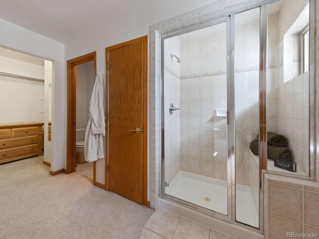 full bathroom featuring tile patterned floors, toilet, and a shower stall