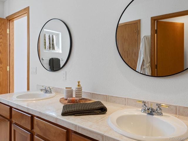 full bathroom with double vanity and a sink