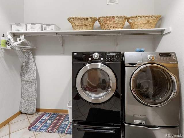 laundry room featuring laundry area, separate washer and dryer, baseboards, and tile patterned floors