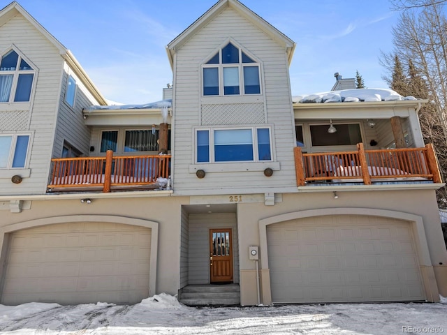 view of front of property with a garage, a balcony, and stucco siding