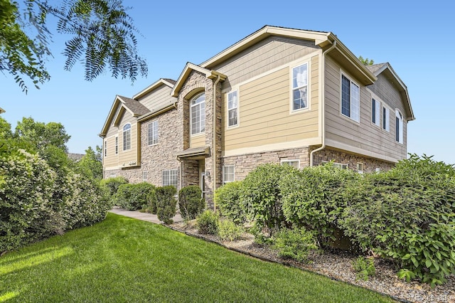 371 Granby Way Unit C, Aurora, CO 80011 - view of side of home featuring stone siding and a yard