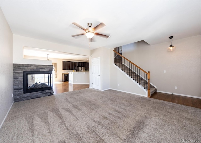 unfurnished living room with a multi sided fireplace, dark hardwood / wood-style flooring, and ceiling fan