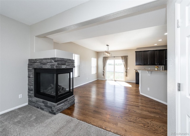 unfurnished living room featuring dark wood-type flooring and a fireplace