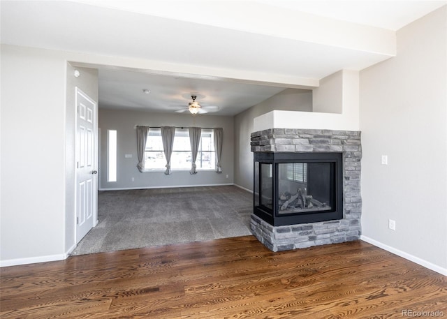 unfurnished living room featuring ceiling fan, a fireplace, and dark wood-type flooring