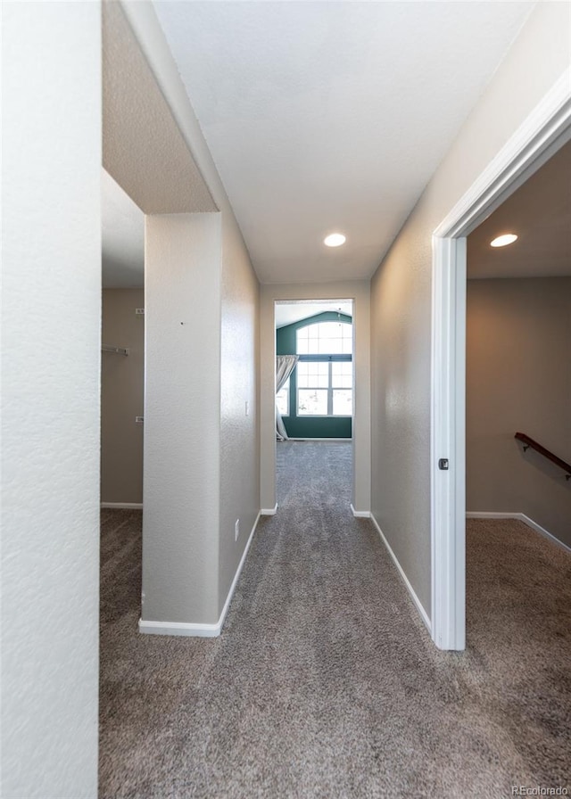 hallway featuring dark colored carpet