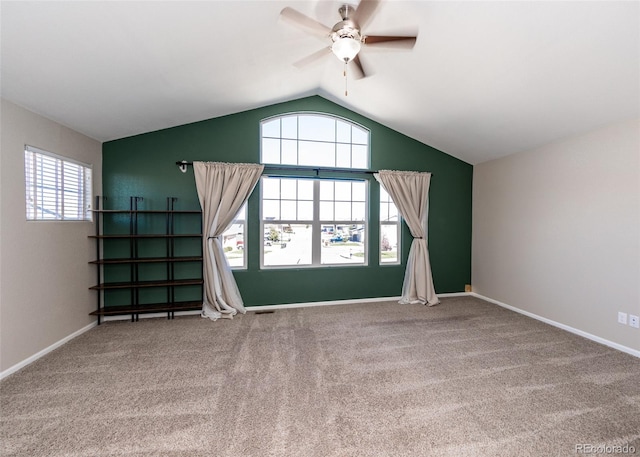 interior space featuring ceiling fan, vaulted ceiling, and carpet