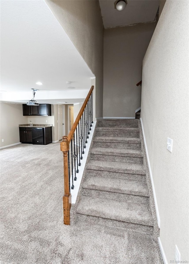 staircase featuring carpet flooring and sink