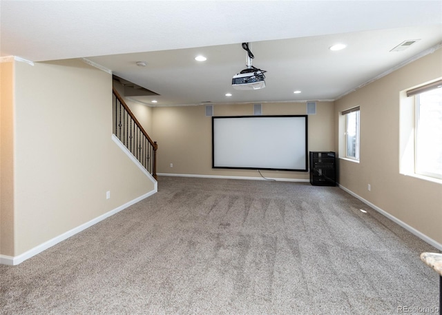 home theater featuring light colored carpet and crown molding