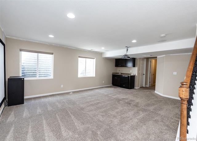 unfurnished living room with light carpet, crown molding, and bar