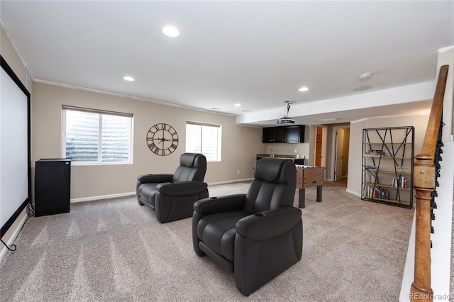 carpeted home theater room featuring ornamental molding