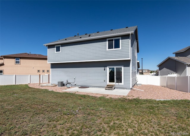 rear view of house with a patio area, central air condition unit, and a yard