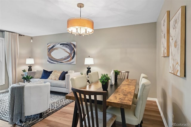 9306 Garrison Dr, Broomfield, CO 80021 - dining area featuring wood finished floors, a chandelier, and baseboards