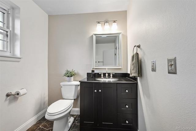 9306 Garrison Dr, Broomfield, CO 80021 - bathroom featuring marble look tiles, toilet, baseboards, and vanity