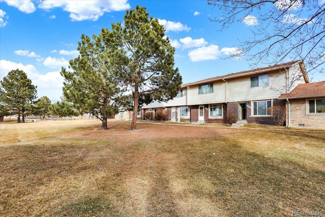 view of front of house featuring brick siding and a front lawn