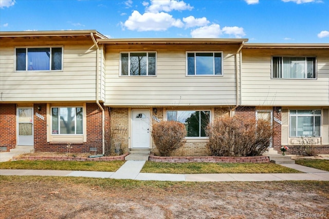 townhome / multi-family property with entry steps and brick siding