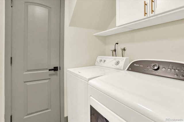 washroom with cabinet space and washer and clothes dryer