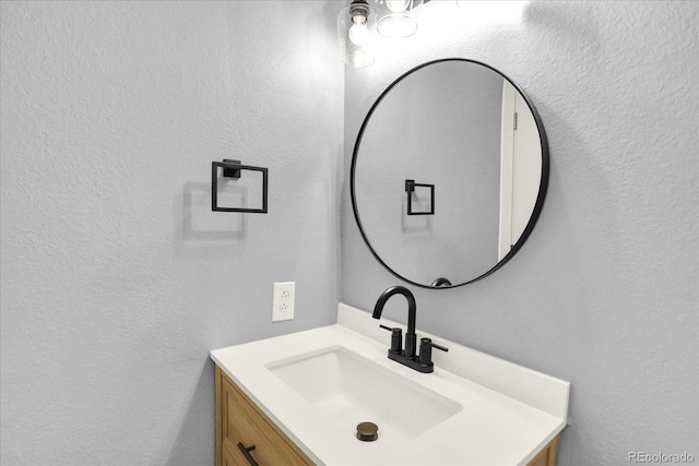 bathroom featuring a textured wall and vanity