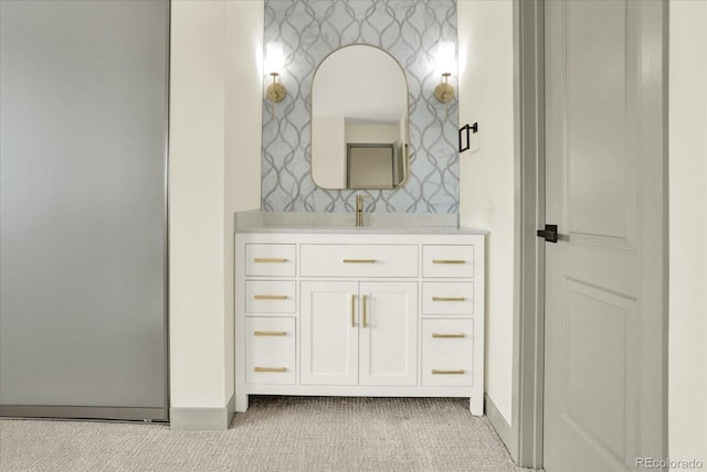 bathroom with vanity, baseboards, and wallpapered walls