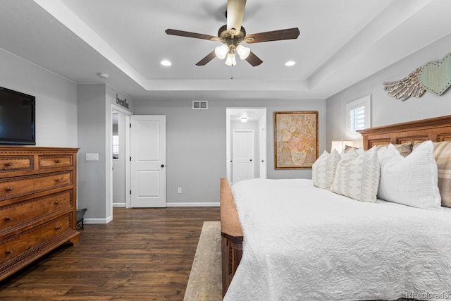 bedroom featuring a tray ceiling, ceiling fan, and dark wood-type flooring