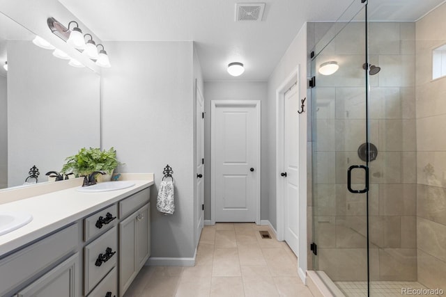 bathroom featuring tile patterned floors, vanity, and a shower with shower door