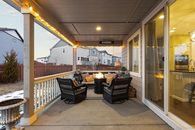 patio terrace at dusk with an outdoor living space with a fire pit