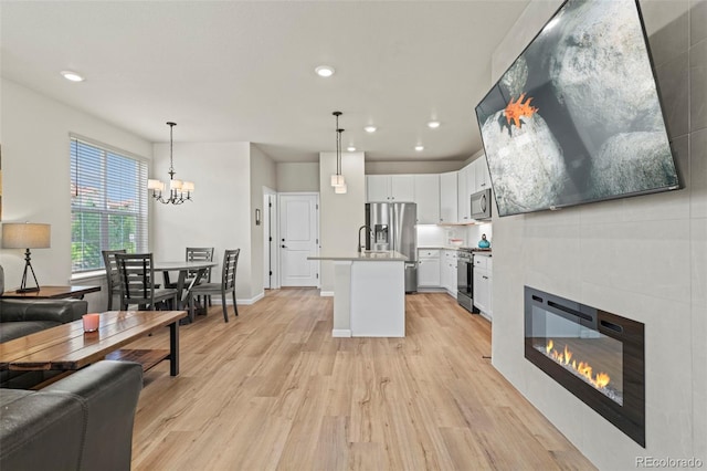 8387 Donati Ter Unit A, Littleton, CO 80129 - living room featuring light wood-type flooring, recessed lighting, a chandelier, and a tile fireplace