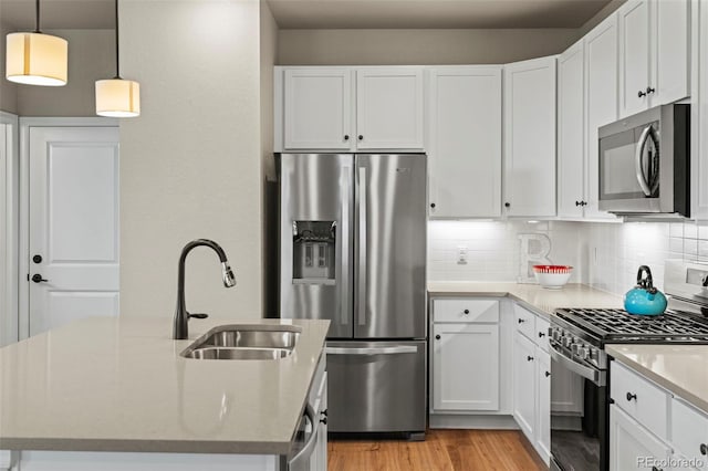 8387 Donati Ter Unit A, Littleton, CO 80129 - kitchen with stainless steel appliances, light wood-style flooring, decorative backsplash, an island with sink, and white cabinets