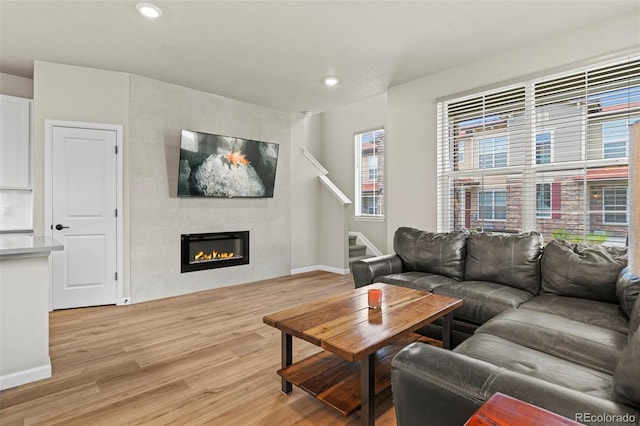 8387 Donati Ter Unit A, Littleton, CO 80129 - living room featuring light wood finished floors, a fireplace, recessed lighting, healthy amount of natural light, and stairs