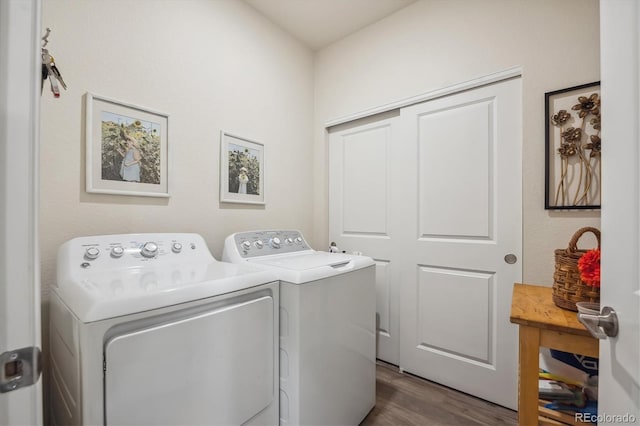 clothes washing area with separate washer and dryer and dark wood-type flooring