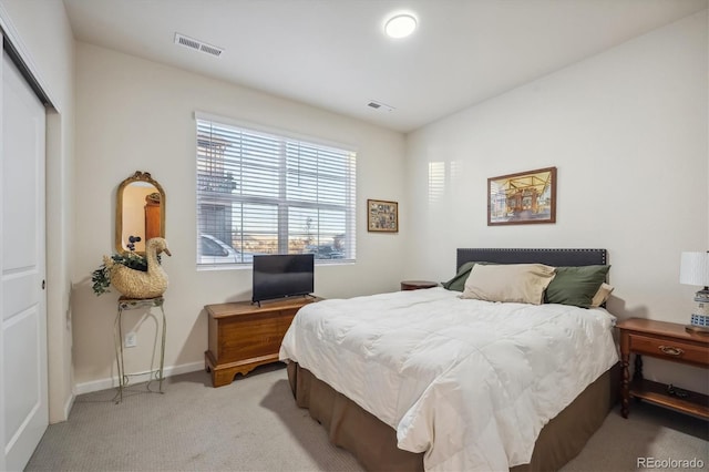 bedroom featuring light carpet and a closet