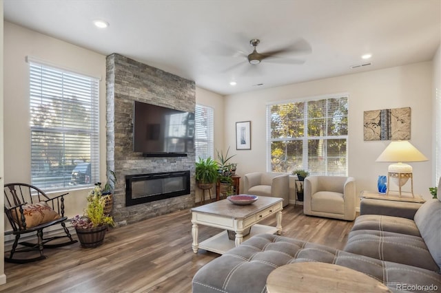 living room with ceiling fan, a fireplace, and hardwood / wood-style flooring