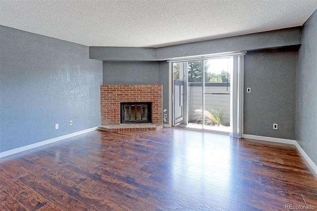 14204 E 1st Dr Unit A12, Aurora, CO 80011 - unfurnished living room with a textured wall, a textured ceiling, wood finished floors, and a fireplace