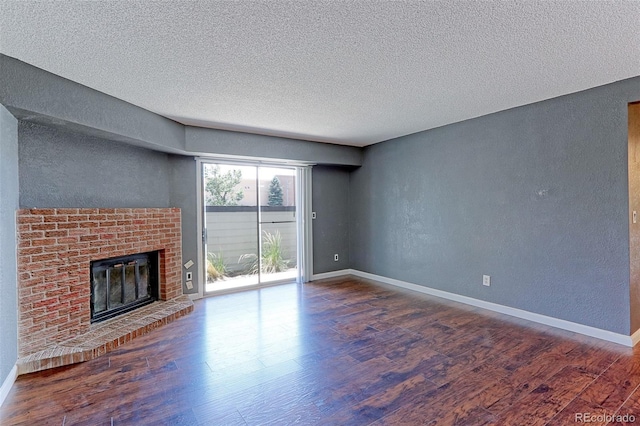 14204 E 1st Dr Unit A12, Aurora, CO 80011 - unfurnished living room with a textured wall, a fireplace, wood finished floors, and a textured ceiling