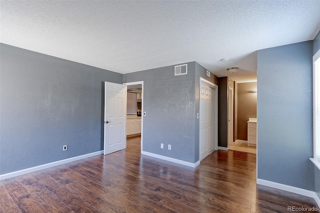 14204 E 1st Dr Unit A12, Aurora, CO 80011 - unfurnished bedroom featuring wood finished floors, a textured ceiling, and a textured wall