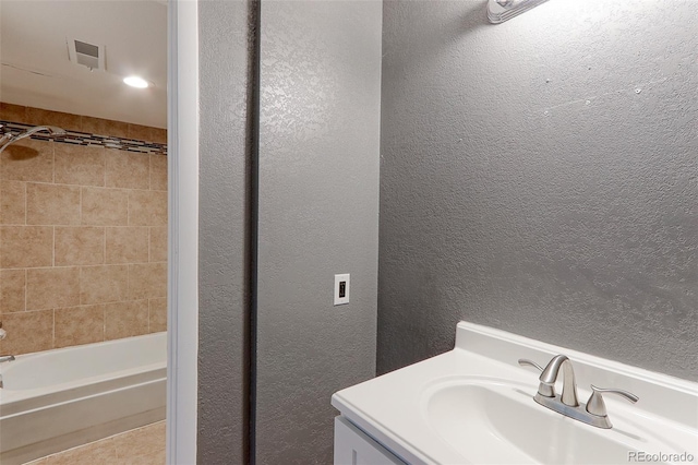 14204 E 1st Dr Unit A12, Aurora, CO 80011 - bathroom with a textured wall, tub / shower combination, vanity, and tile patterned flooring