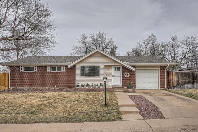 single story home with fence, a garage, concrete driveway, a front yard, and brick siding