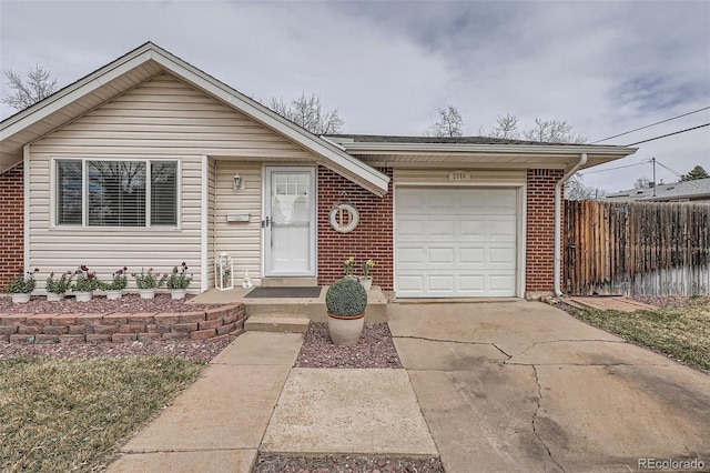 view of front facade with brick siding, fence, a garage, and concrete driveway