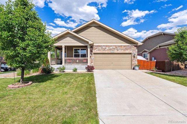10288 Olathe Way, Commerce City, CO 80022 - view of front of house featuring covered porch, driveway, an attached garage, and stone siding