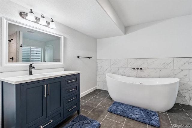 10288 Olathe Way, Commerce City, CO 80022 - bathroom with a soaking tub, tile walls, vanity, a wainscoted wall, and tile patterned flooring